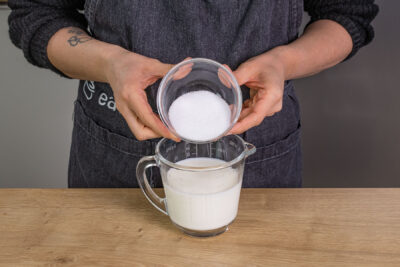 Zucker zu Milch und Wasser geben