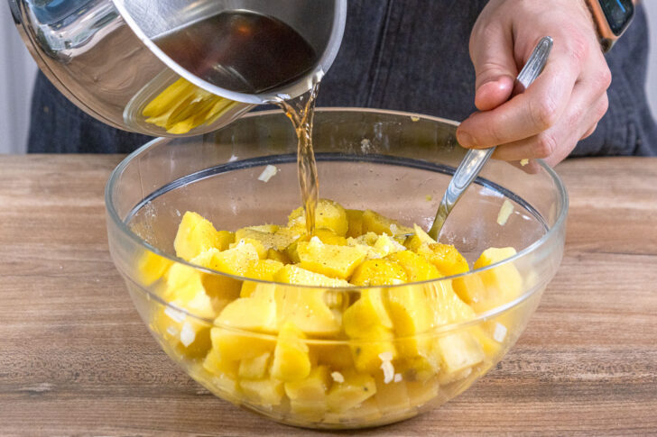 Brühe zum Kartoffelsalat geben