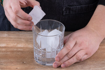 Eiswürfel ins Glas geben