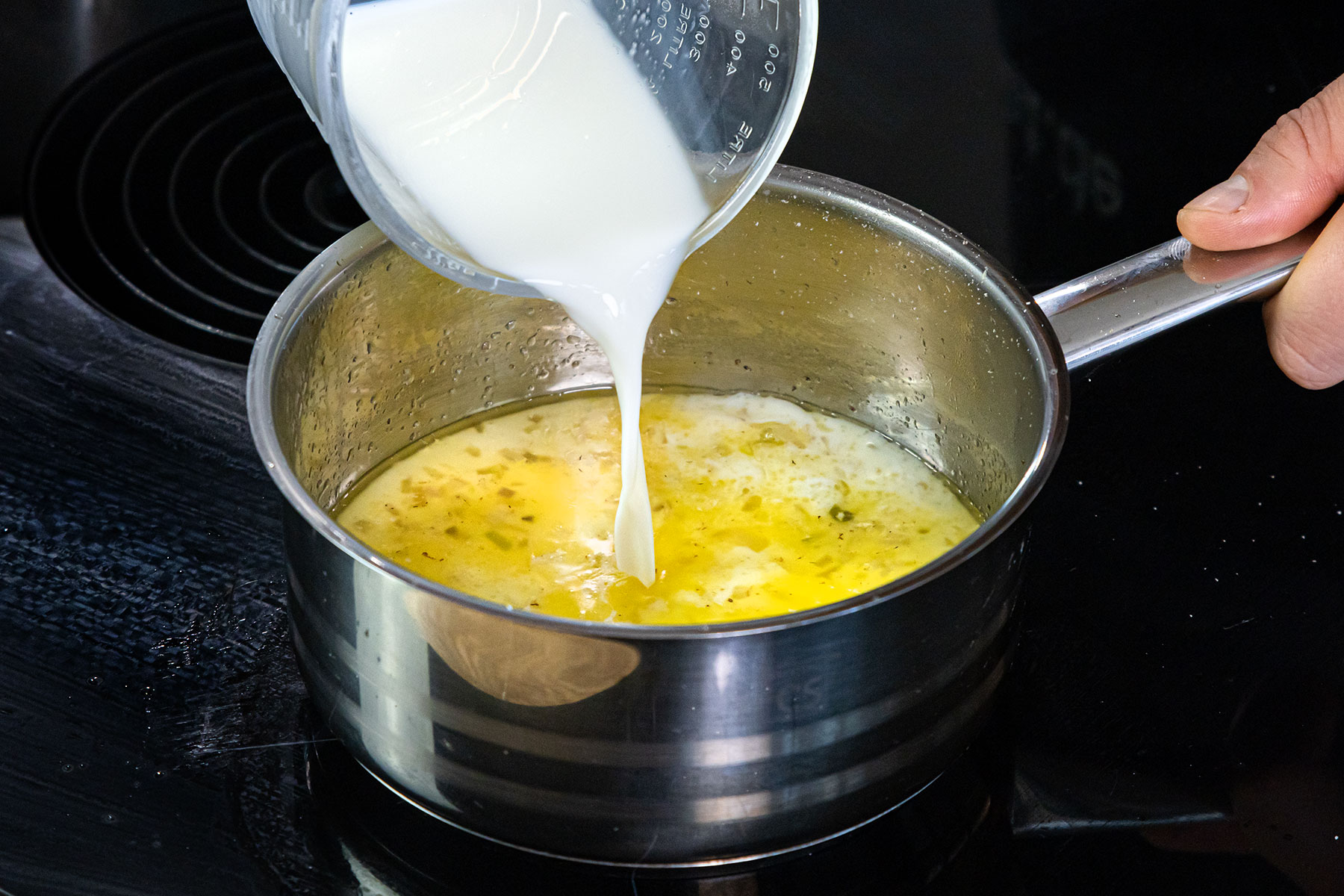 Milch zu den Schalotten geben und erhitzen