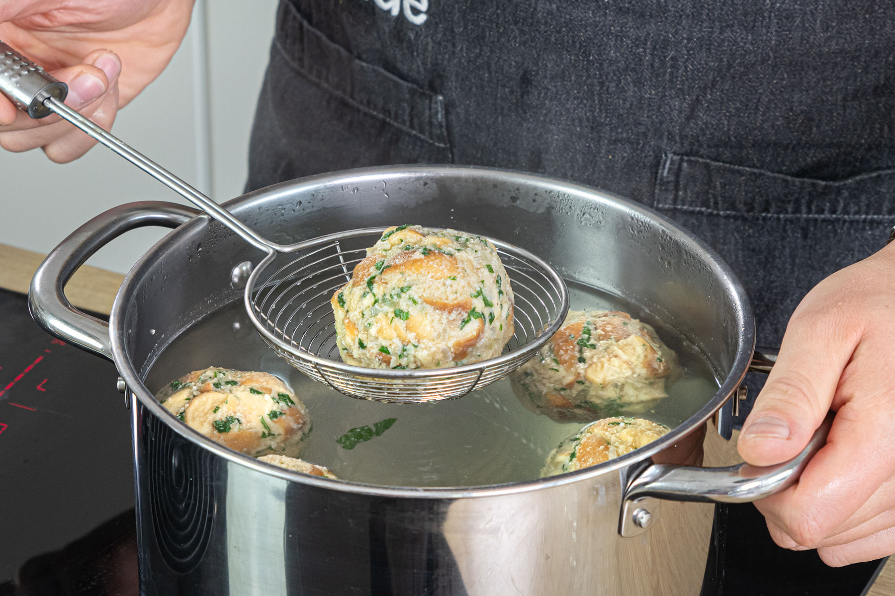 Brezelknödel in heißen Wasser gar ziehen lassen
