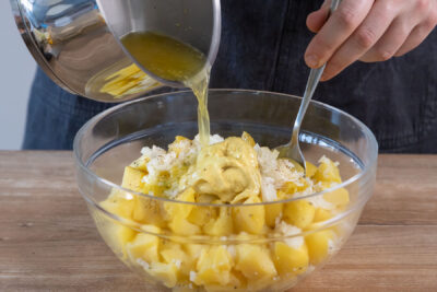Brühe zum Kartoffelsalat geben