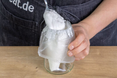 Eiweißspritzglasur in einen Spritzbeutel füllen