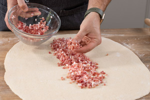 Schinkenspeck auf Handbrot verteilen