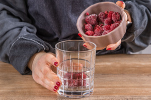 Himbeeren in das Glas geben