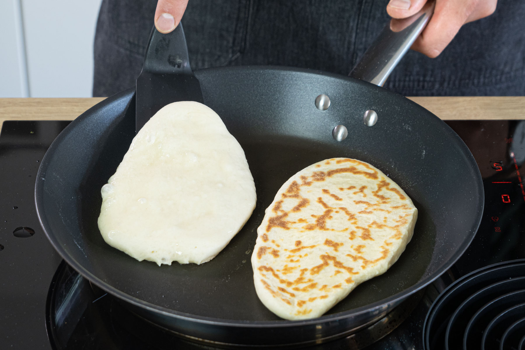 Indisches Naan Brot in der Pfanne ausbacken