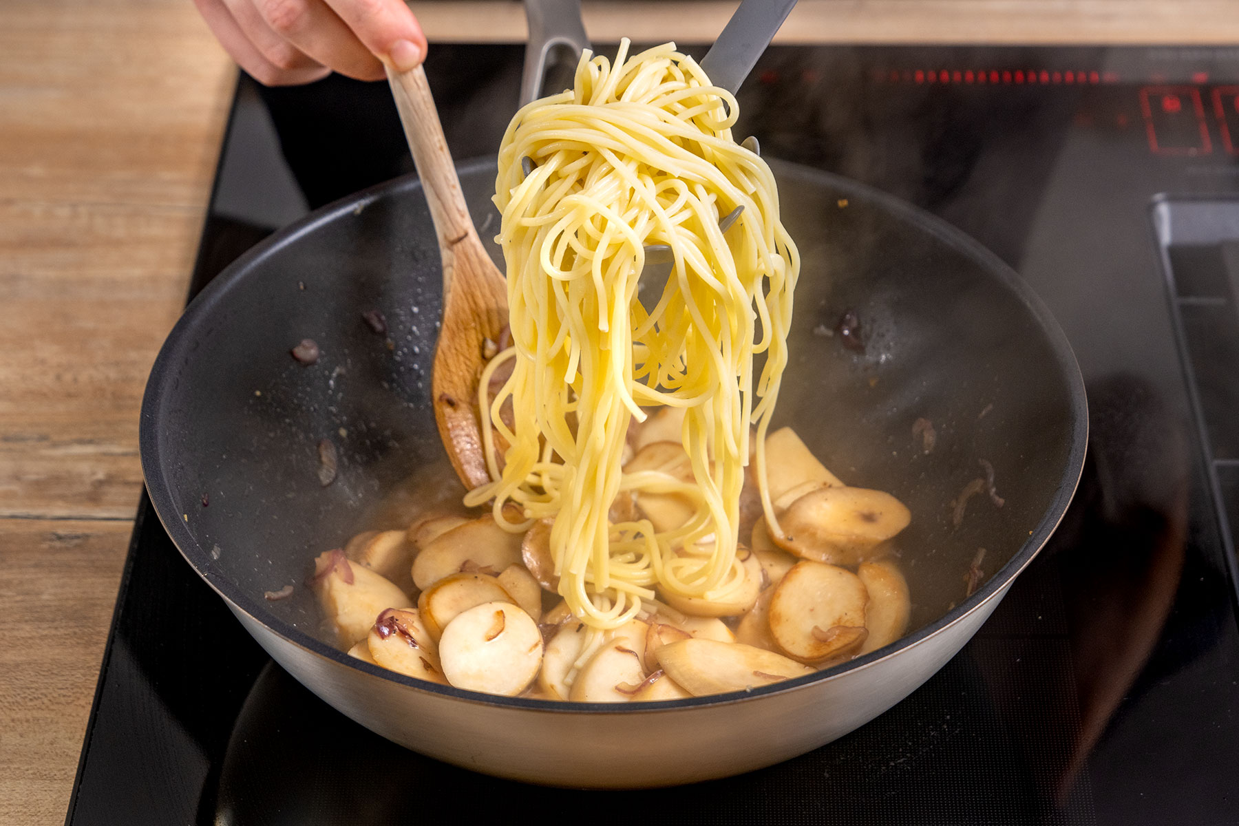 Spaghetti zu den Kräuterseitlingen geben