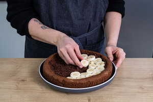 Bananenstücke auf Kuchenboden verteilen
