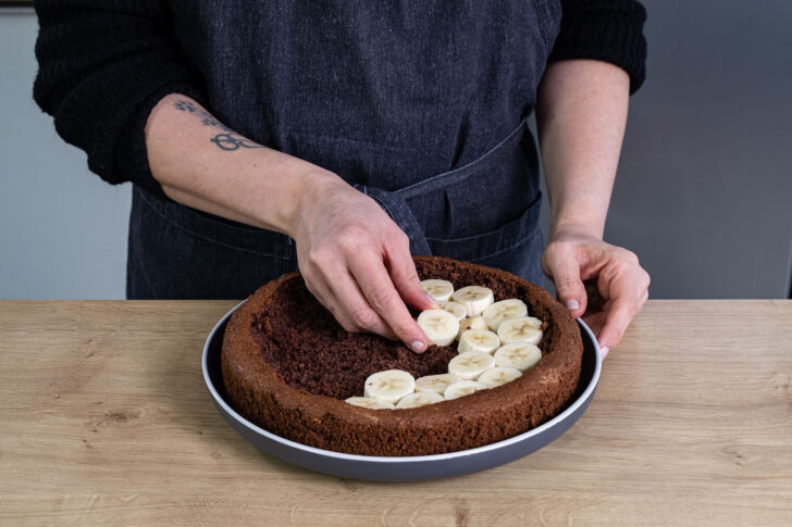 Bananenstücke auf Kuchenboden verteilen