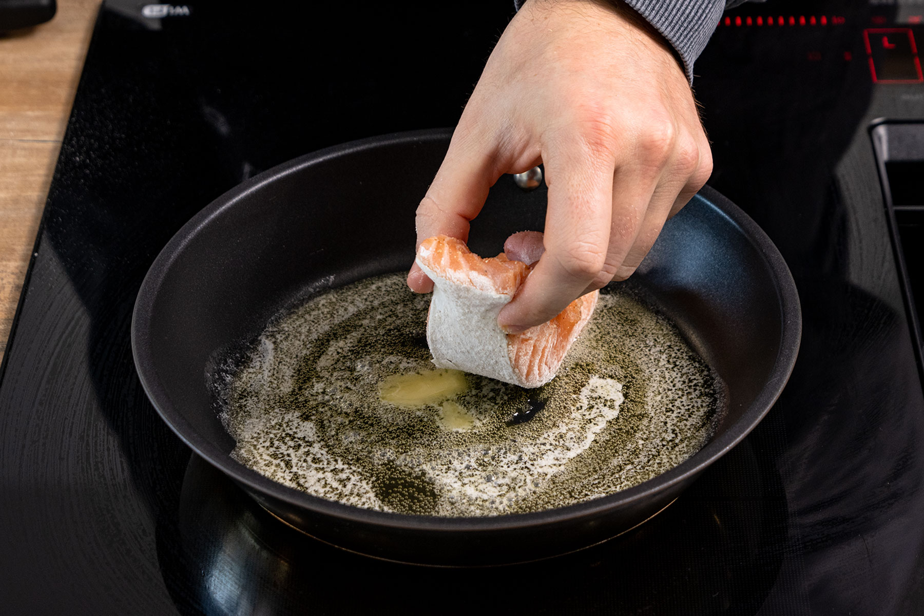 Lachsfilet in Pfanne legen