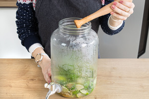 Minze und Limetten mit dem Stößel zerdrücken