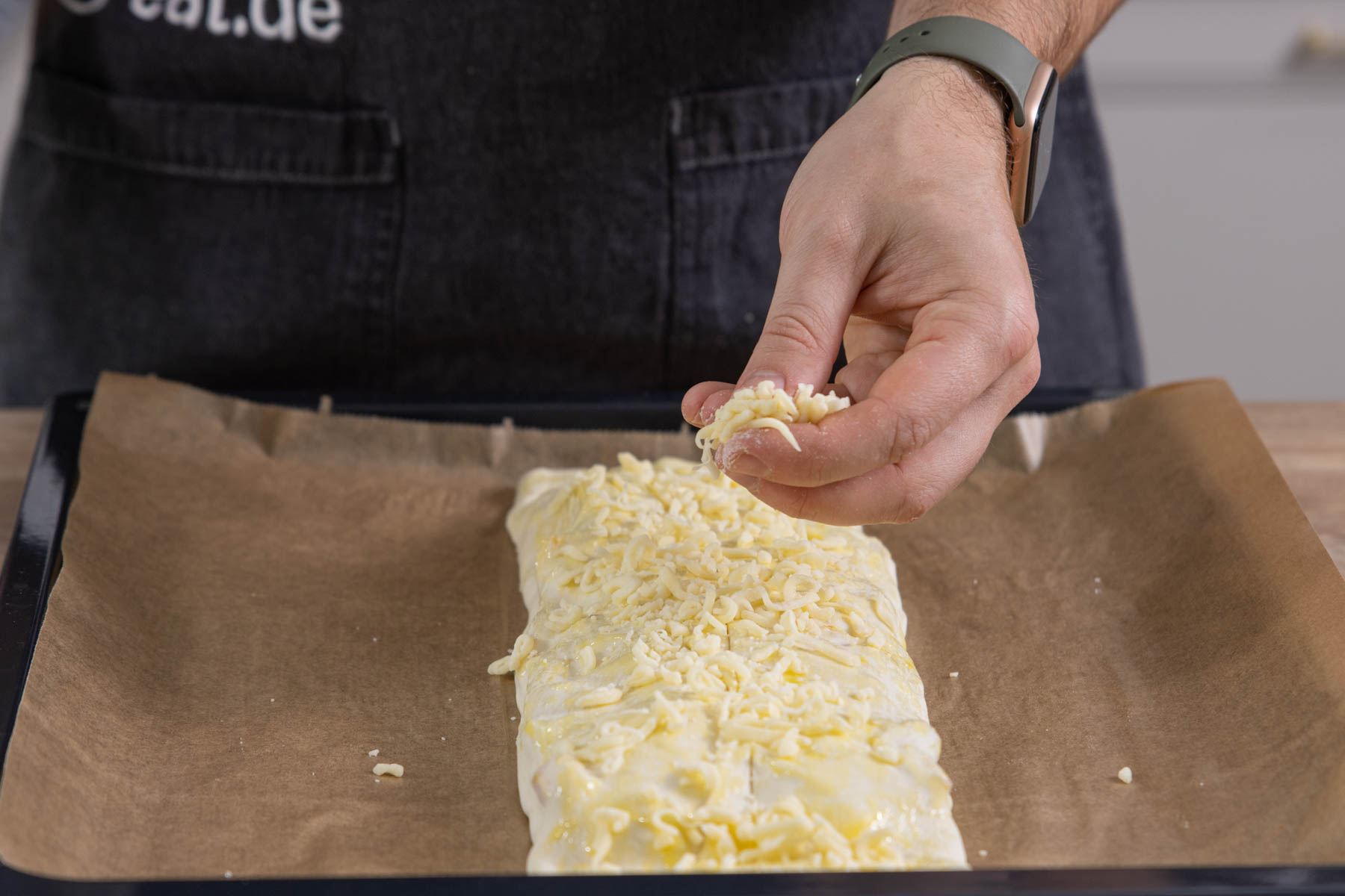 Pizza-Strudel mit Käse bestreuen