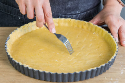 Den Quiche- und Tarteteig mit einer Gabel einstechen