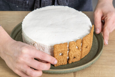 Gewürzspekulatius an den Rand der Spekulatius-Torte drücken