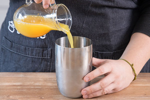 Zutaten in den Cocktailshaker gießen
