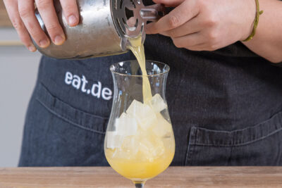Bahama Mama ins mit Eis gefüllte Cocktailglas geben