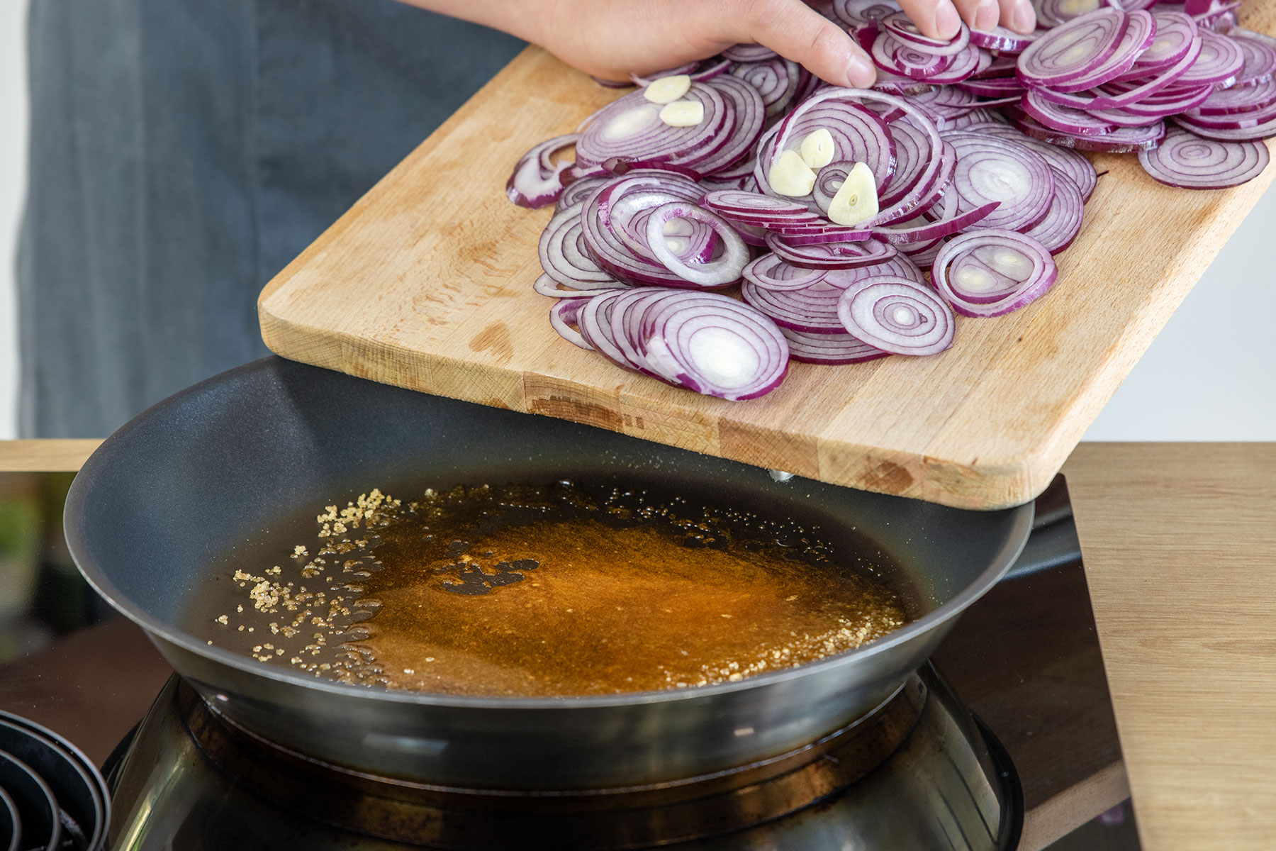 Zwiebelringe zum flüssigen Zucker geben