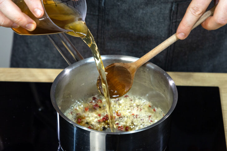 Gemüsebrühe zur Pfeffersauce geben