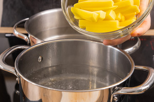 Kartoffeln in den Topf mit Wasser geben