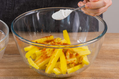 Pommes mit Salz, Paprikapulver und Stärke würzen