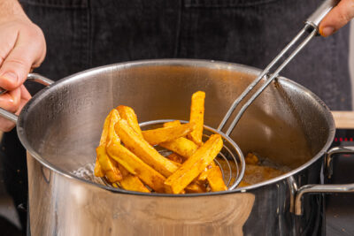 Fette Fritten frittieren bis sie goldbraun sind