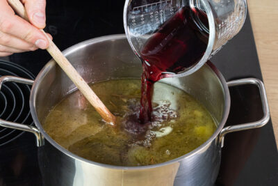 Rotwein zum Soßenansatz gießen