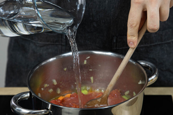 Wasser zur Bohnensuppe gießen