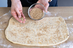 Teig mit Sesam bestreuen