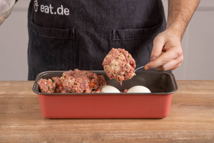 Eier mit Hackfleisch bedecken