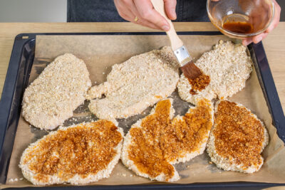 Hähnchenschnitzel mit dem Öl betupfen