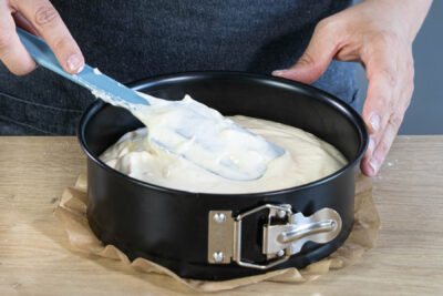 Biskuitteig in die Springform füllen und den Tortenboden backen