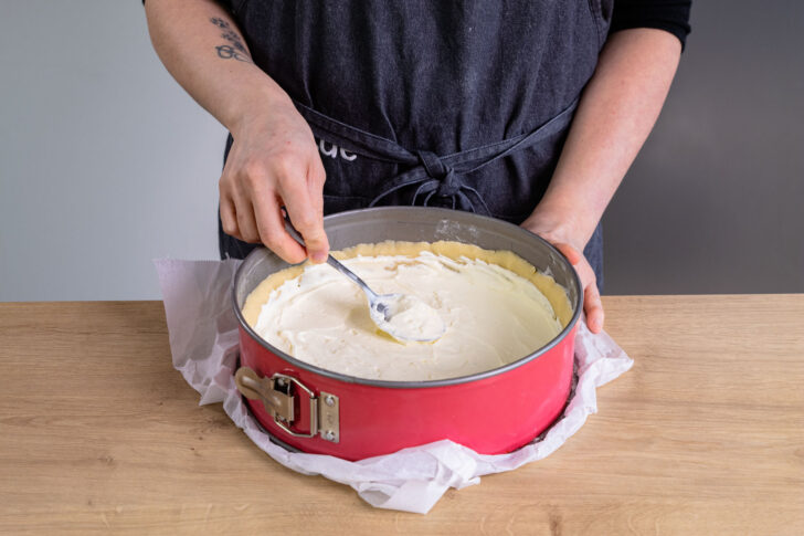 Käsekuchenmasse auf Teigboden verteilen