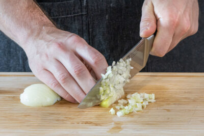 Zwiebeln und Knoblauch würfeln
