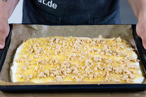 Streusel auf Kirmeskuchen verteilen