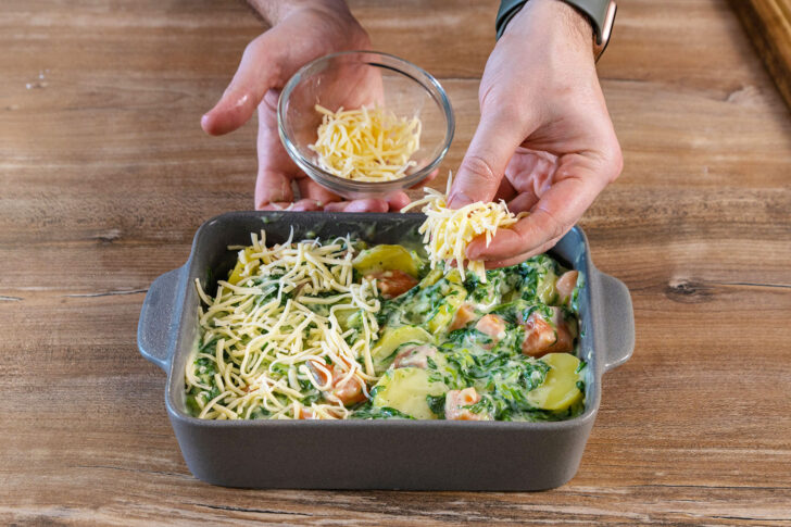 Lachs-Kartoffel-Auflauf mit Käse bestreuen