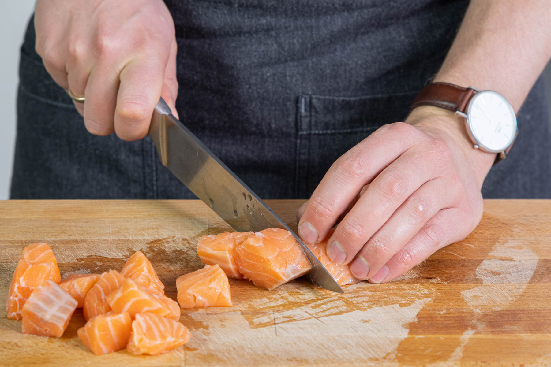 Lachs in Würfel schneiden.
