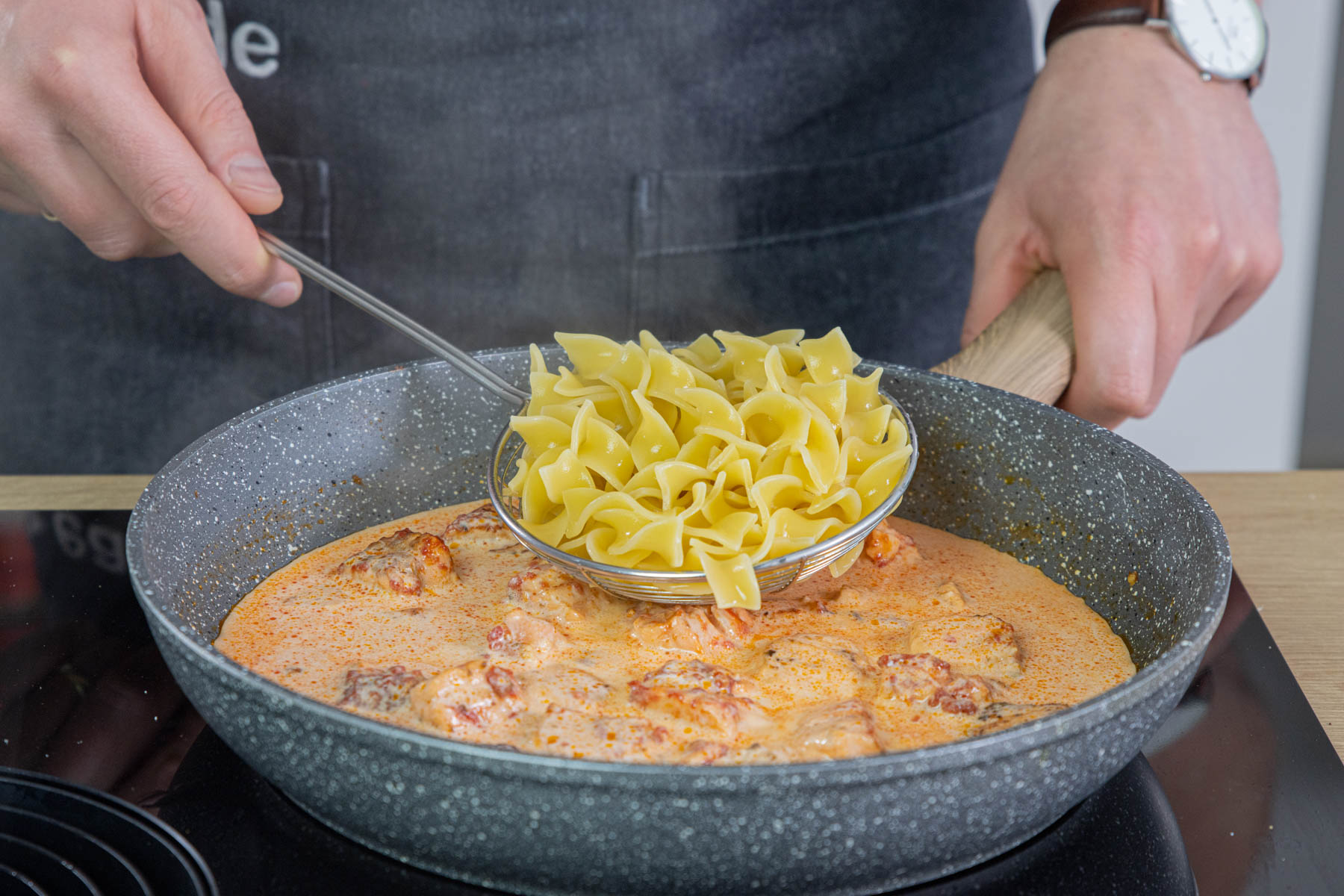 Nudeln in die Lachs Sahnesoße geben