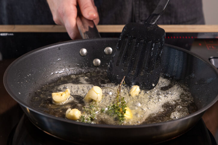 Knoblauch und Thymian in Pfanne schwenken
