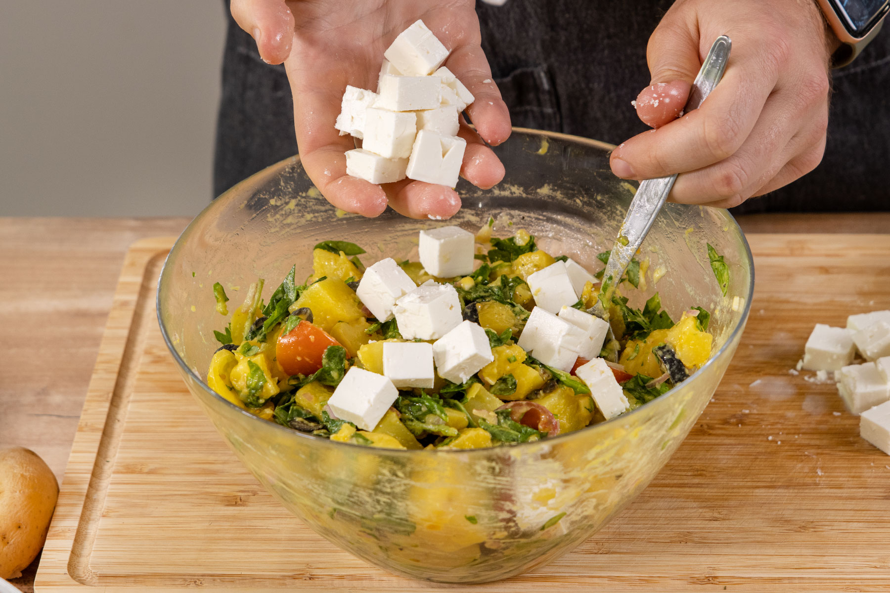 Feta in den mediterranen Kartoffelsalat geben