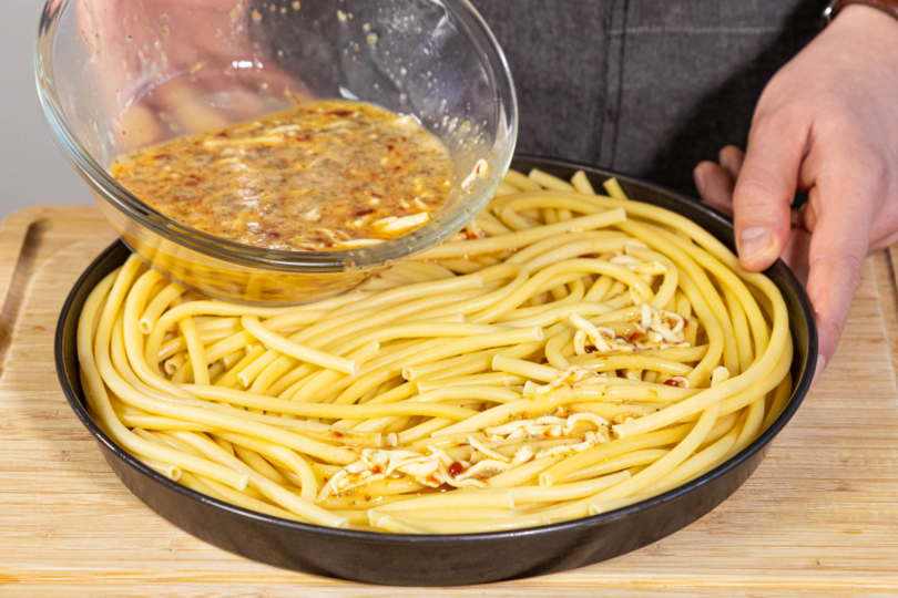 Ei-Käse-Masse über die Nudeln verteilen