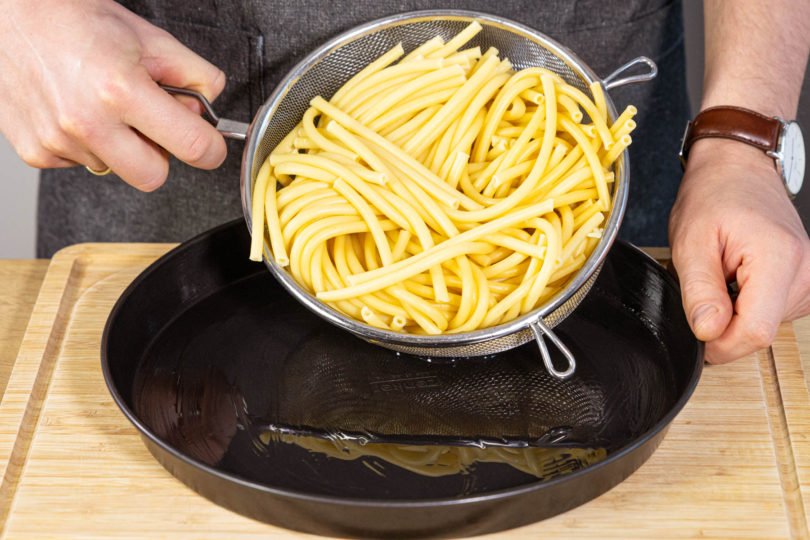 vorgekochte Makkaroni in die Form geben