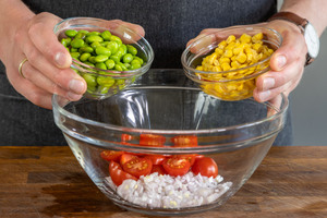 Edamame und Mais zum Salat geben