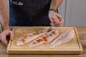 Pangasiusfilet mit Paprikapulver würzen