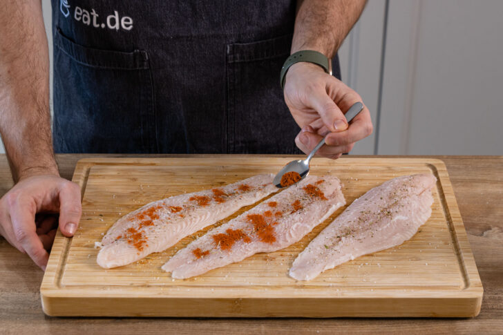 Pangasiusfilet mit Paprikapulver würzen