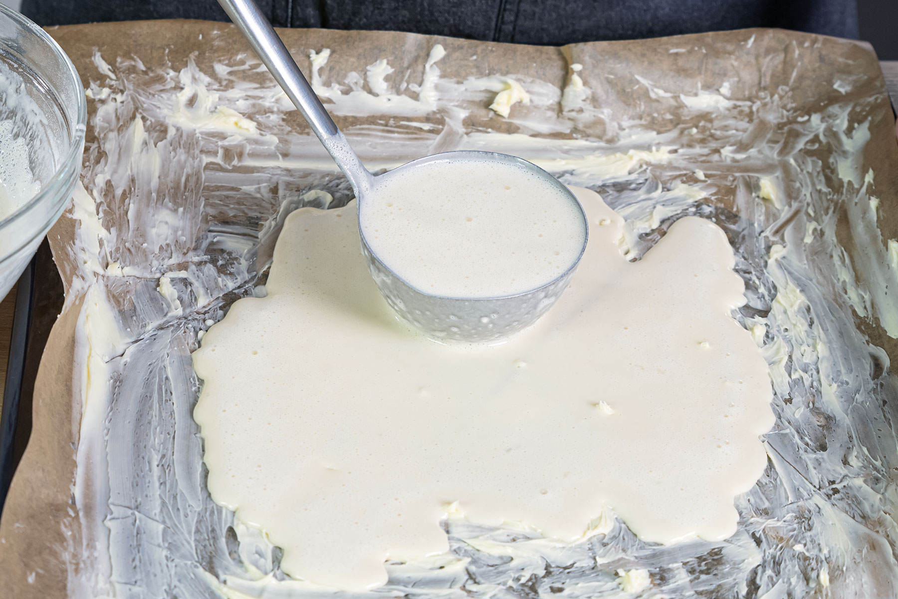 Pfannkuchenteig auf dem Backblech verteilen