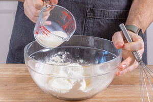 Milch zu Mehl und Quark gießen