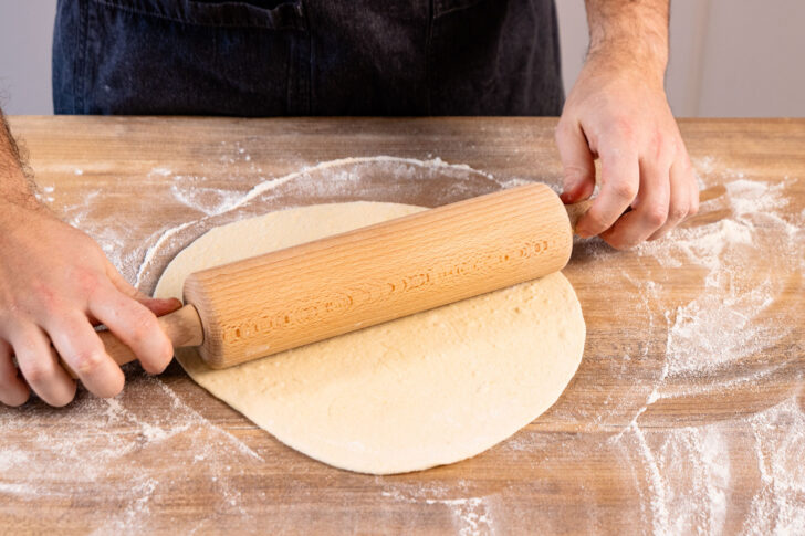 Pizzateig ausrollen.