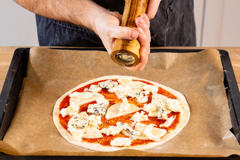 Pizza würzen.