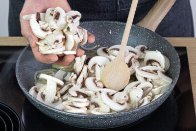 Zwiebeln und Champignons anbraten