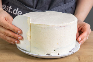 Regenbogenkuchen mit Creme einstreichen